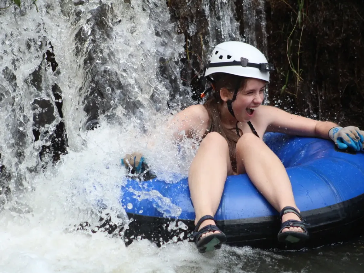 a young girl riding a wave on a surfboard in the water