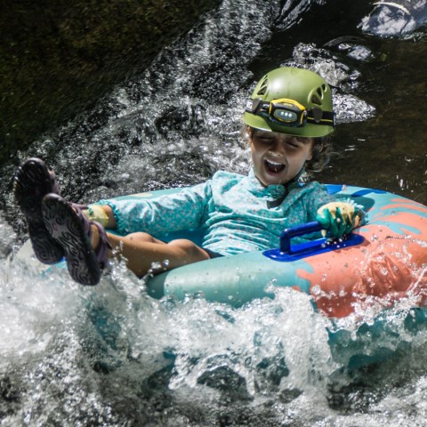 a young boy riding a wave on a surfboard in the water