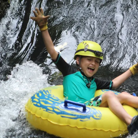 a young girl riding a wave on a surfboard in the water